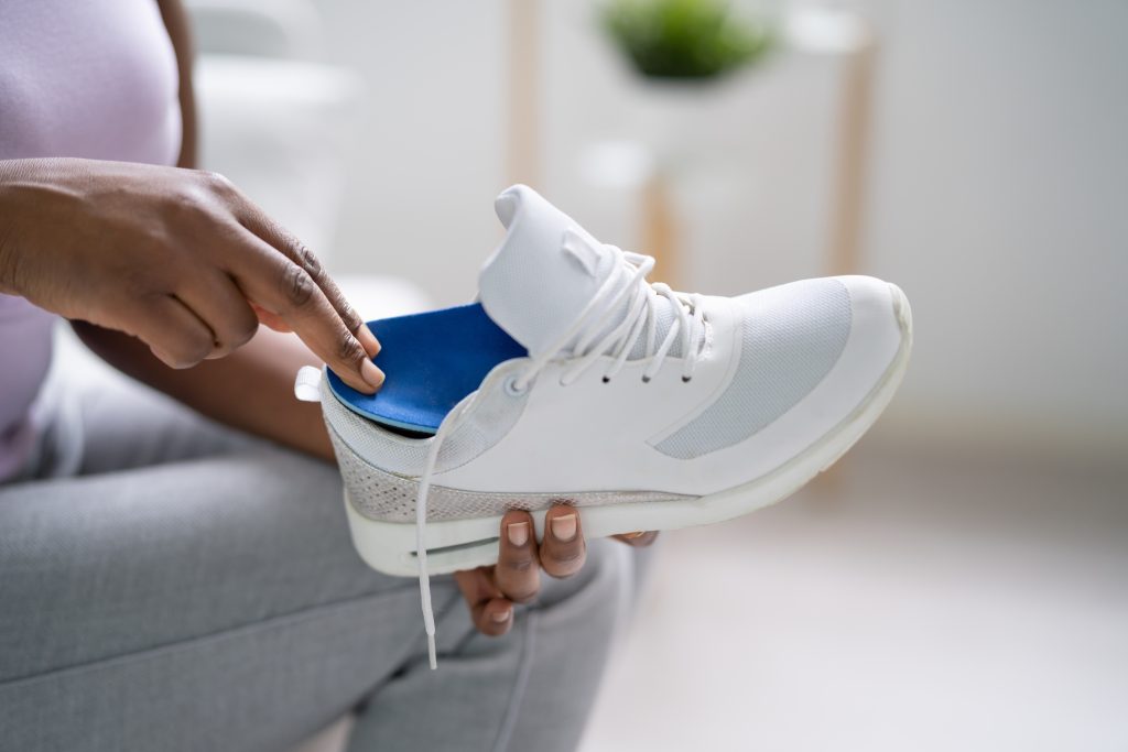 Vrouw legt steunzool in haar schoen.
